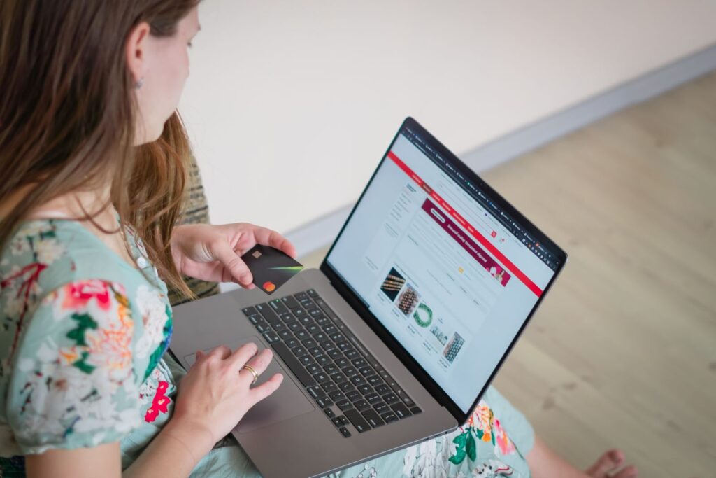Kobieta robiąca zakupy online na laptopie z kartą płatniczą w ręku