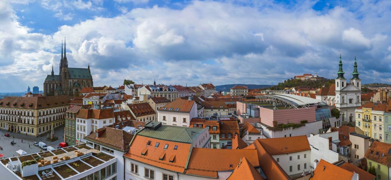 Panorama Brna se střechami historického centra, katedrálou na Petrově a hradem Špilberk