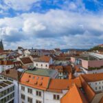 Panorama Brna se střechami historického centra, katedrálou na Petrově a hradem Špilberk