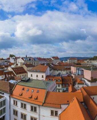 Panorama Brna se střechami historického centra, katedrálou na Petrově a hradem Špilberk