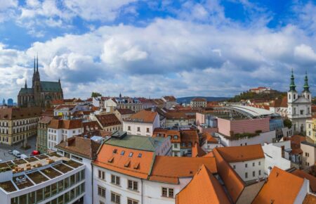 Panorama Brna se střechami historického centra, katedrálou na Petrově a hradem Špilberk
