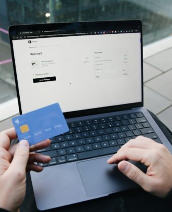 Ruce s platební kartou nad notebookem při nákupu na internetu
