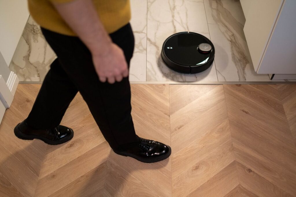 Robot sprzątający pracujący na drewnianej podłodze
