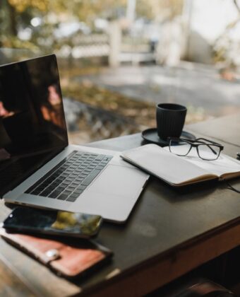 Laptop, notes i kawa na drewnianym biurku przy oknie