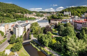 Letecký pohled na Karlovy Vary s řekou Teplou a lázeňskými domy v zeleni