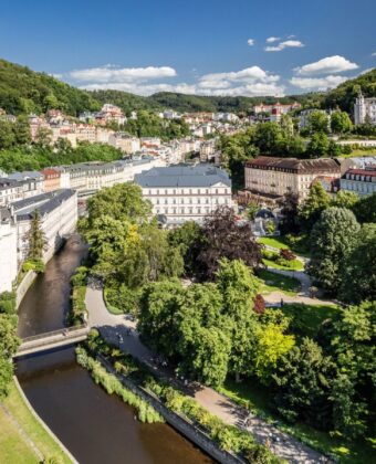 Letecký pohled na Karlovy Vary s řekou Teplou a lázeňskými domy v zeleni