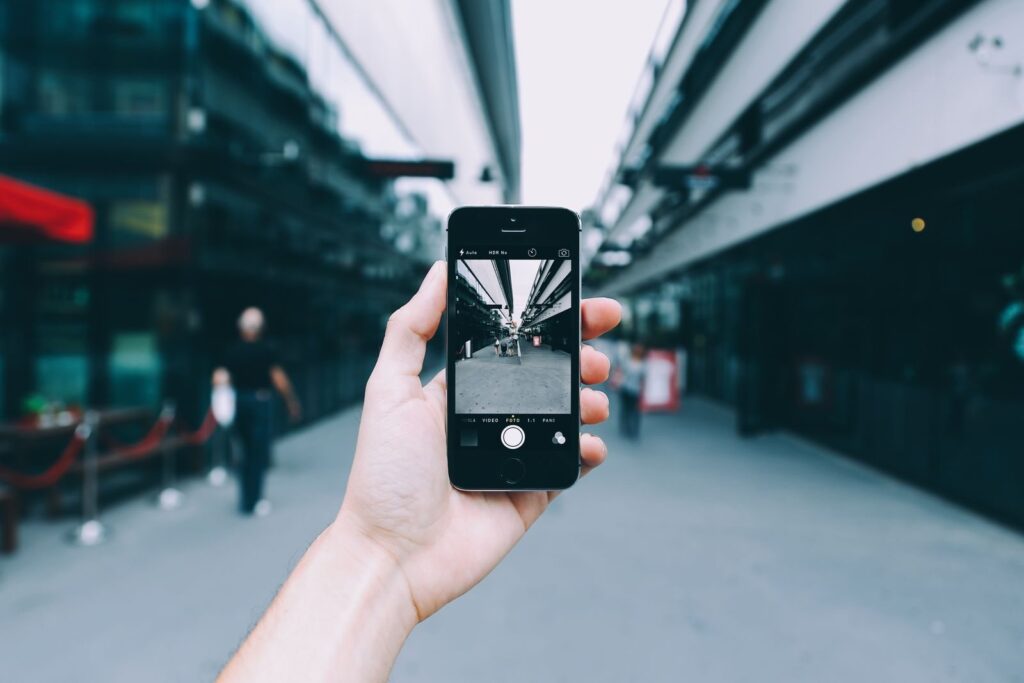 Dłoń robiąca smartfonem zdjęcie miejskiej ulicy
